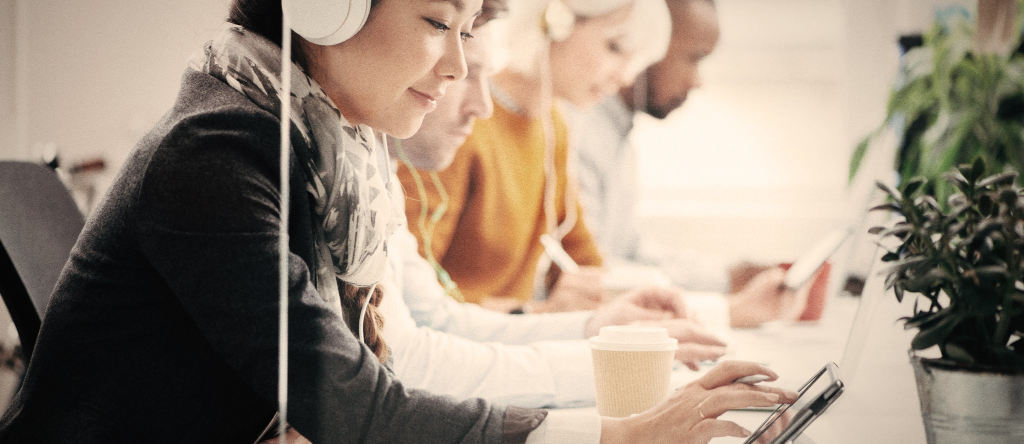 Grupo de personas estudiando con auriculares y tablets