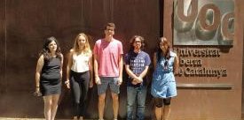 Cinco estudiantes en prácticas de la UOC delante del edificio de la universidad
