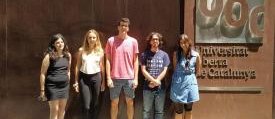 Cinco estudiantes en prácticas de la UOC delante del edificio de la universidad